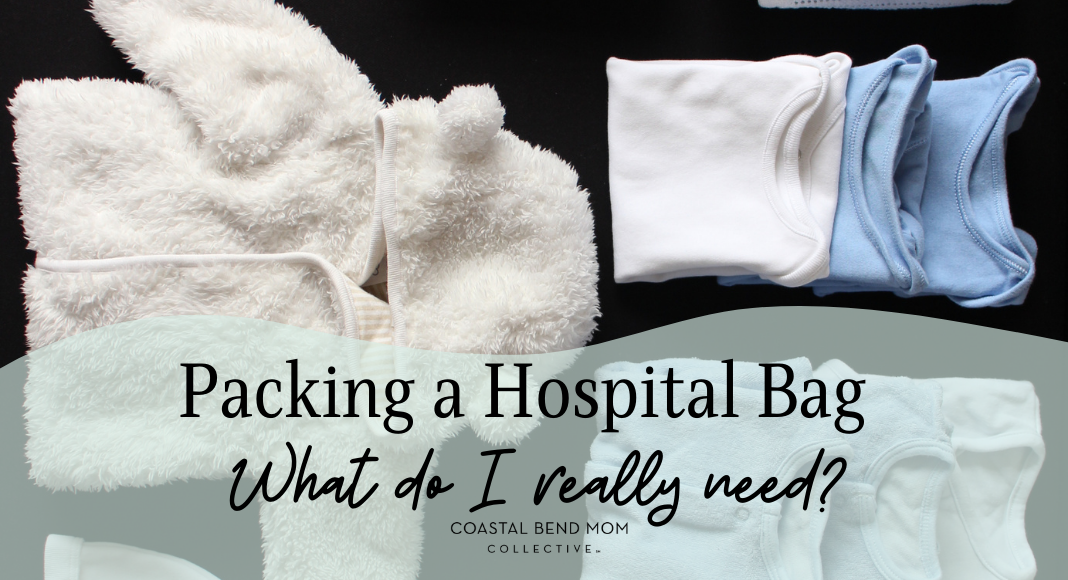 Image of baby clothing laid out, ready to pack. Clothing includes a fuzzy white jacket with hood, two blue onesies and one white onesie, folded up. The text overlay reads: Packing a Hospital Bag: What I really Need: Coastal Bend Mom Collective