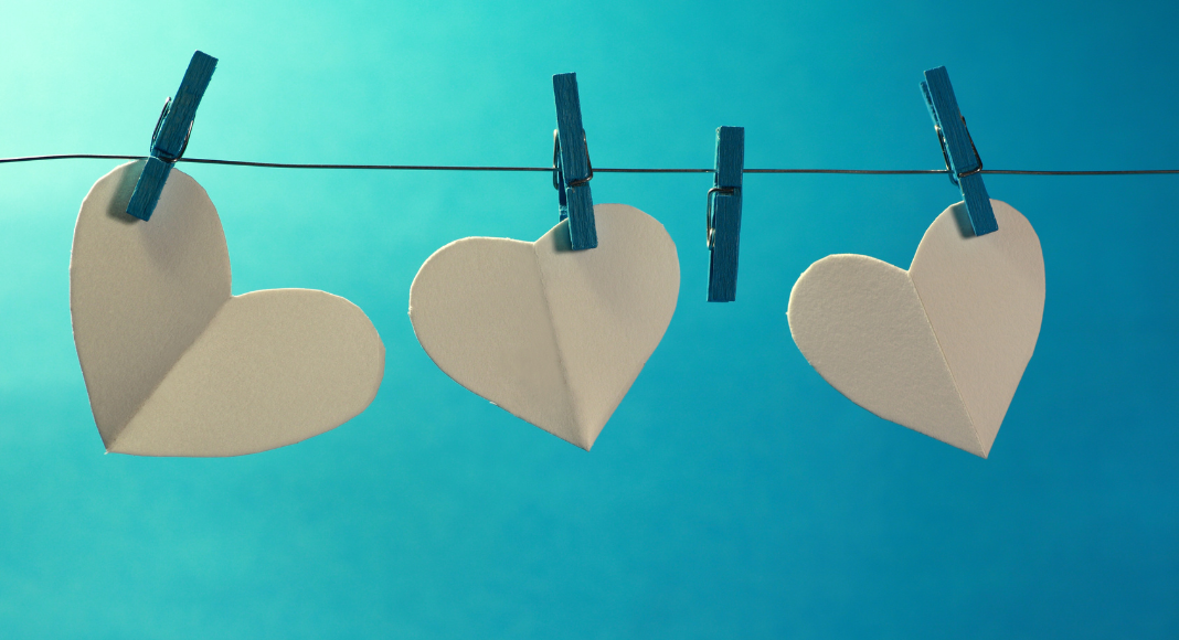 Pregnancy and Infant Loss - Four clothespins hanging on a line, three of the hold a cut out heart. One of them is not holding anything.