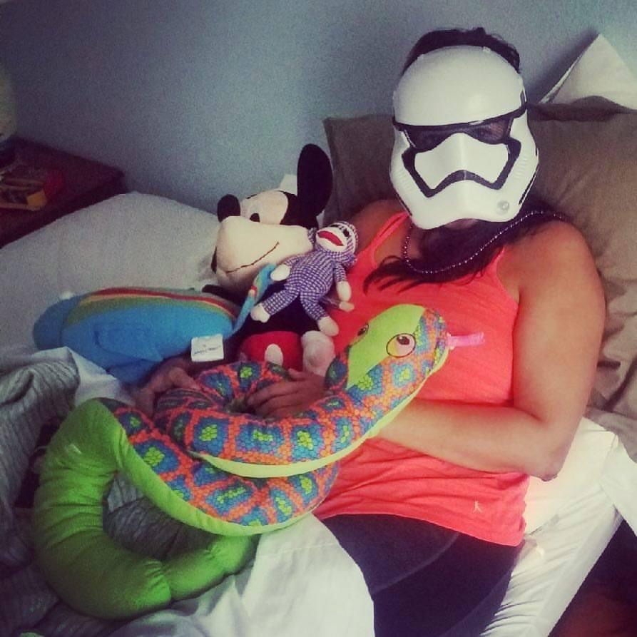 Woman (Amanda Weaver) wearing Storm Trooper mask, surrounded by stuffed animals