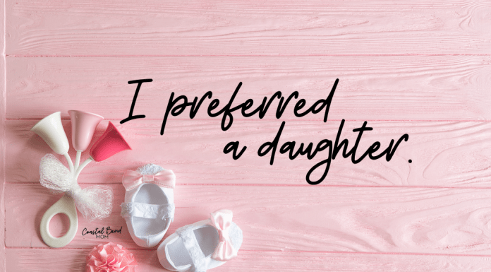 Image reads "I preferred a daughter." Pink background with pink accented baby toy and white baby shoes with pink bows.