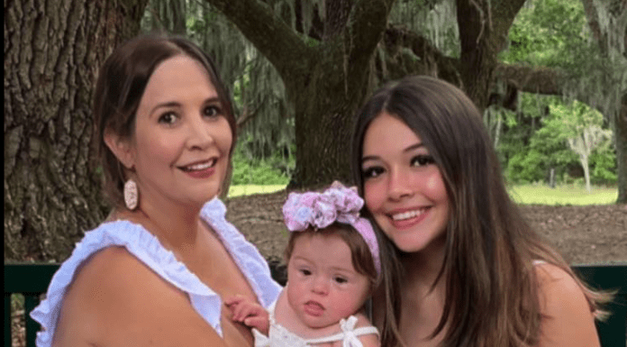 Amanda Weaver with her daughters, an adorable baby girl with Down's syndrome, and a beautiful teenaged girl with long brown hair.