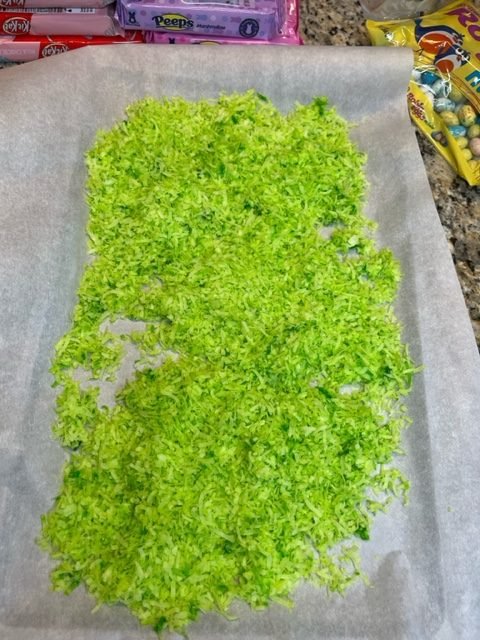 Green coconut flakes, "curing" on a baking sheet lined with parchment paper.